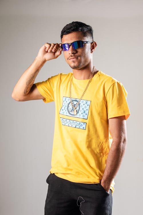 Young Man in Yellow T-Shirt Posing with Sunglasses