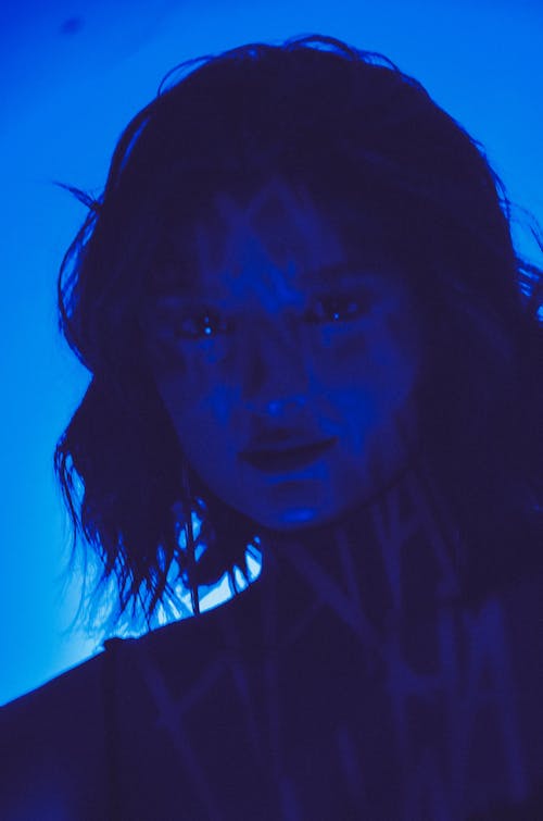 Blue Light on Face of Posing Woman