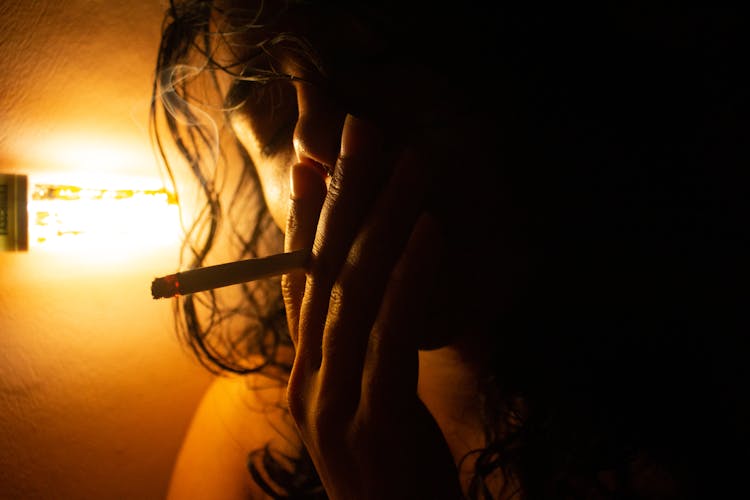 Light Over Woman Face And Hand Holding Cigarette