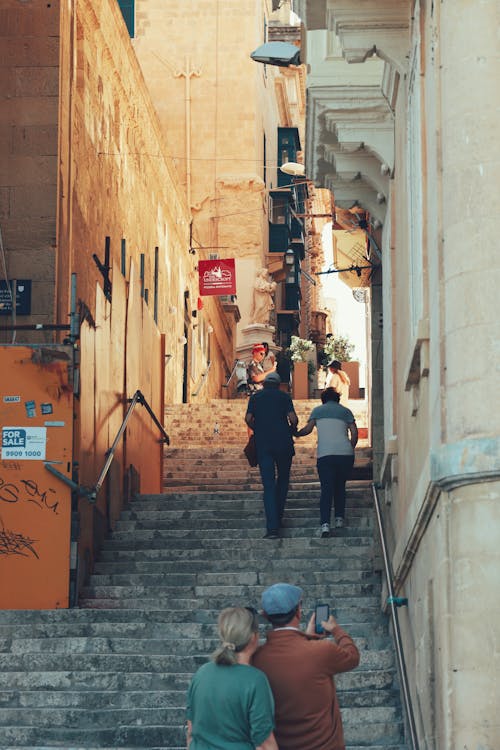 View of People Walking on Steps between Buildings in a Town 