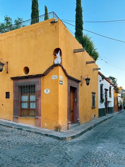 Free Yellow facade on a cobblestone street corner in San Miguel de Allende, Mexico. Stock Photo