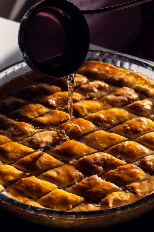 Photo of Baklava with a Ladle Pouring Sugar Syrup on It