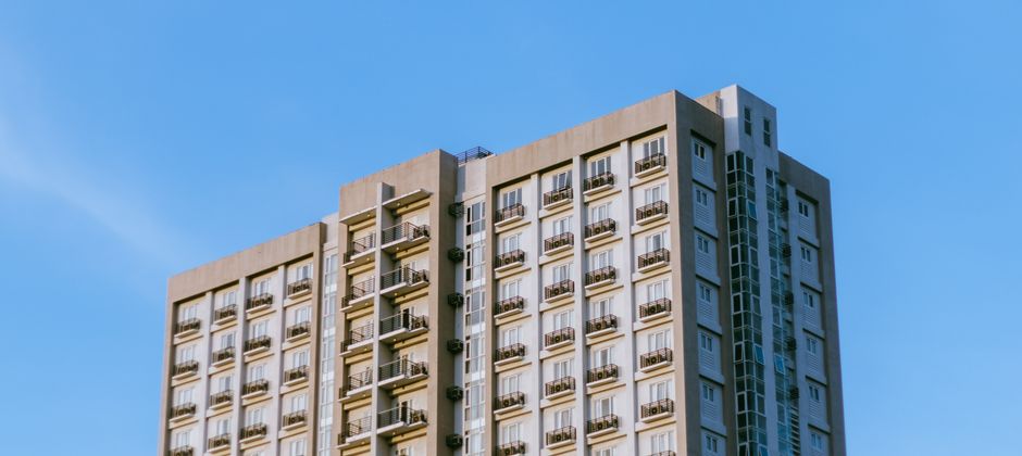 A high-rise apartment block with stacked balconies — every unit connected by the same vertical services
