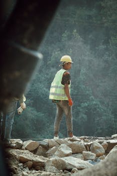 A construction worker wearing safety gear amidst rocky terrain in Butwal, Nepal.