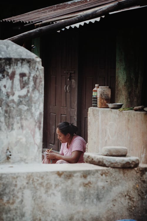 Woman Sitting behind Wall