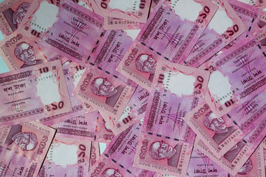Various Bangladeshi Taka notes in a flat lay pattern, showcasing the vibrant currency.