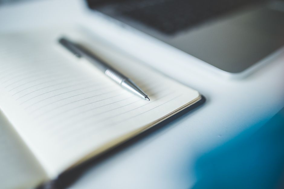 notebook and pen on desk natural light lifestyle photo 1