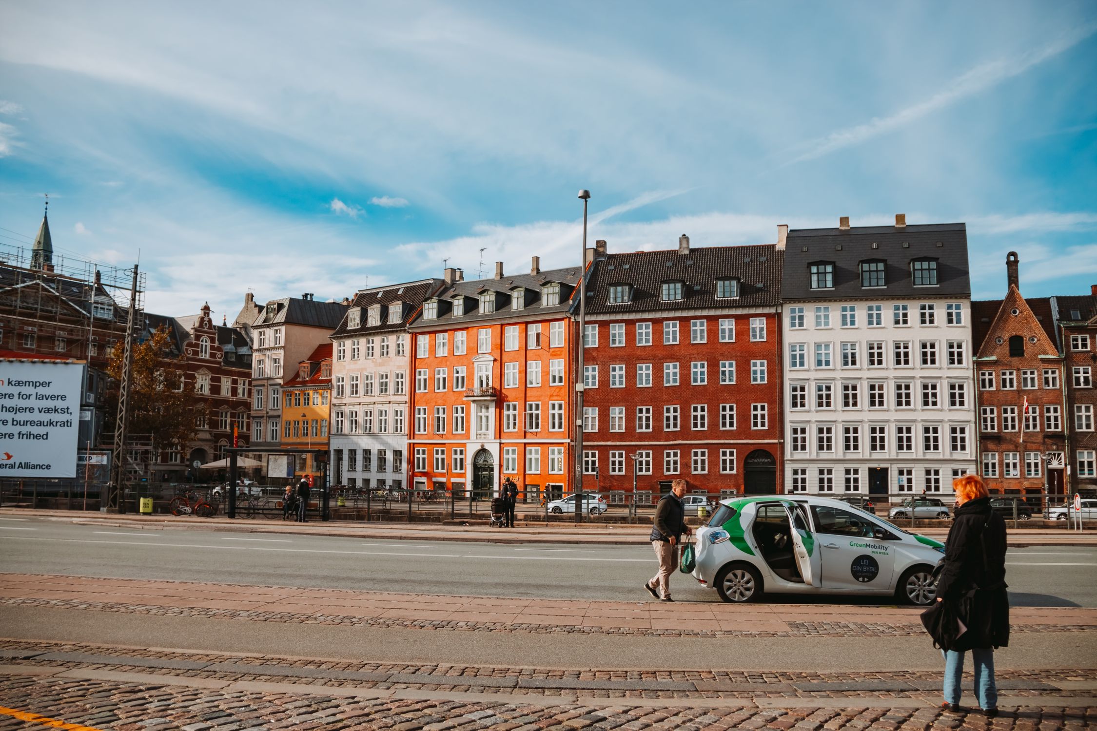 Vibrant historical buildings line a street in Copenhagen, Denmark during daytime