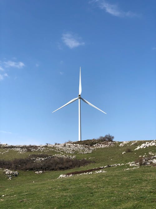 A Wind Turbine of a Field under Blue Sky 