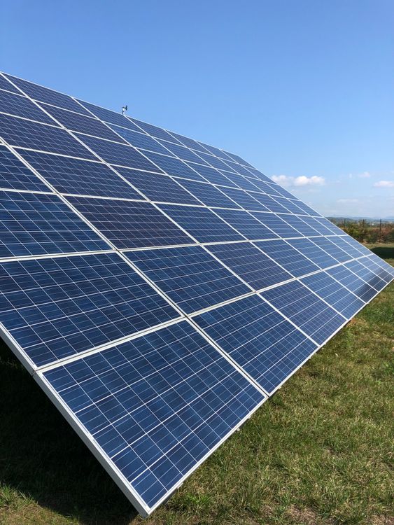 Free Solar panels in a green field on a sunny day, showcasing renewable energy in Tortona, Italy. Stock Photo