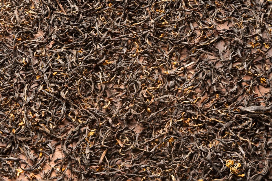 Detailed close-up of organic loose leaf black tea with rich texture.