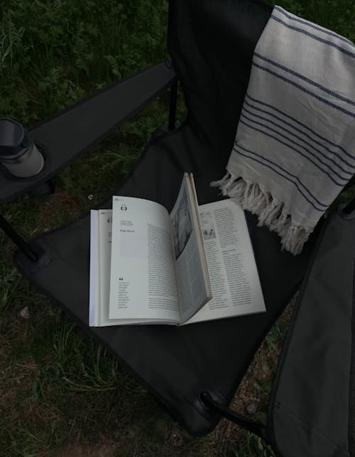 A Book on a Folding Chair Outdoors 