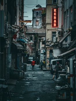 Moody urban alleyway with neon sign and narrow street, capturing everyday life.
