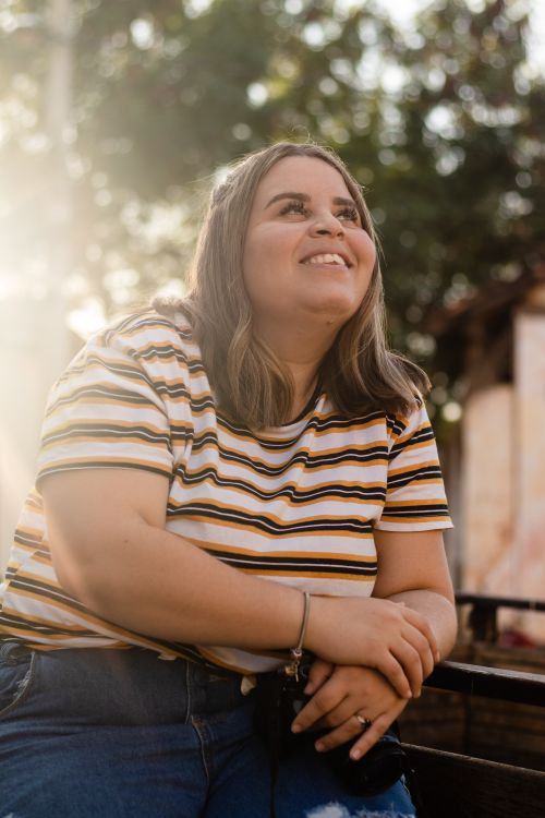 Free Happy woman enjoying the sunny outdoors in casual attire. Stock Photo