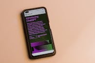 Webpage of ChatGPT, a prototype AI chatbot, is seen on the website of OpenAI, on a smartphone. Examples, capabilities, and limitations are shown.