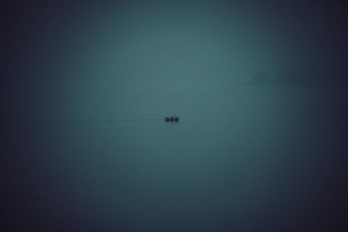 Silhouette of Boat in Water in Fog
