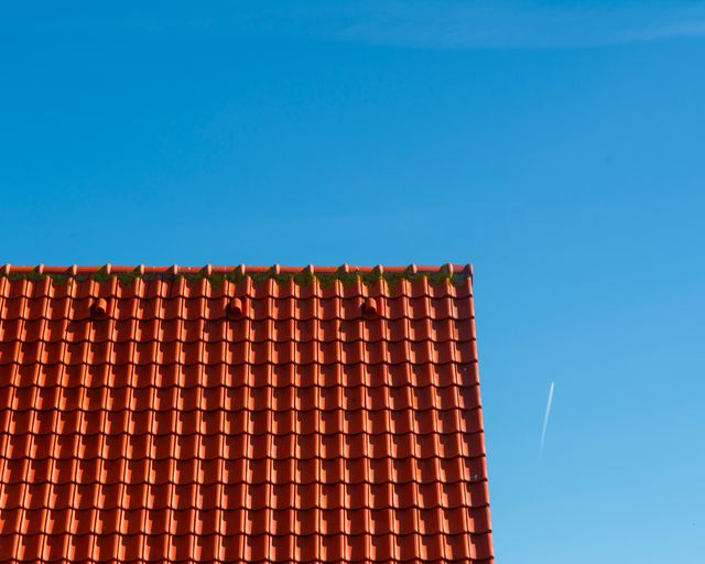 Red clay tile roof Red clay tile rooftop against a clear blue sky