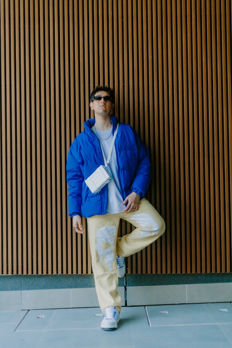 Stylish Young Man In Sunglasses Posing Near Wall