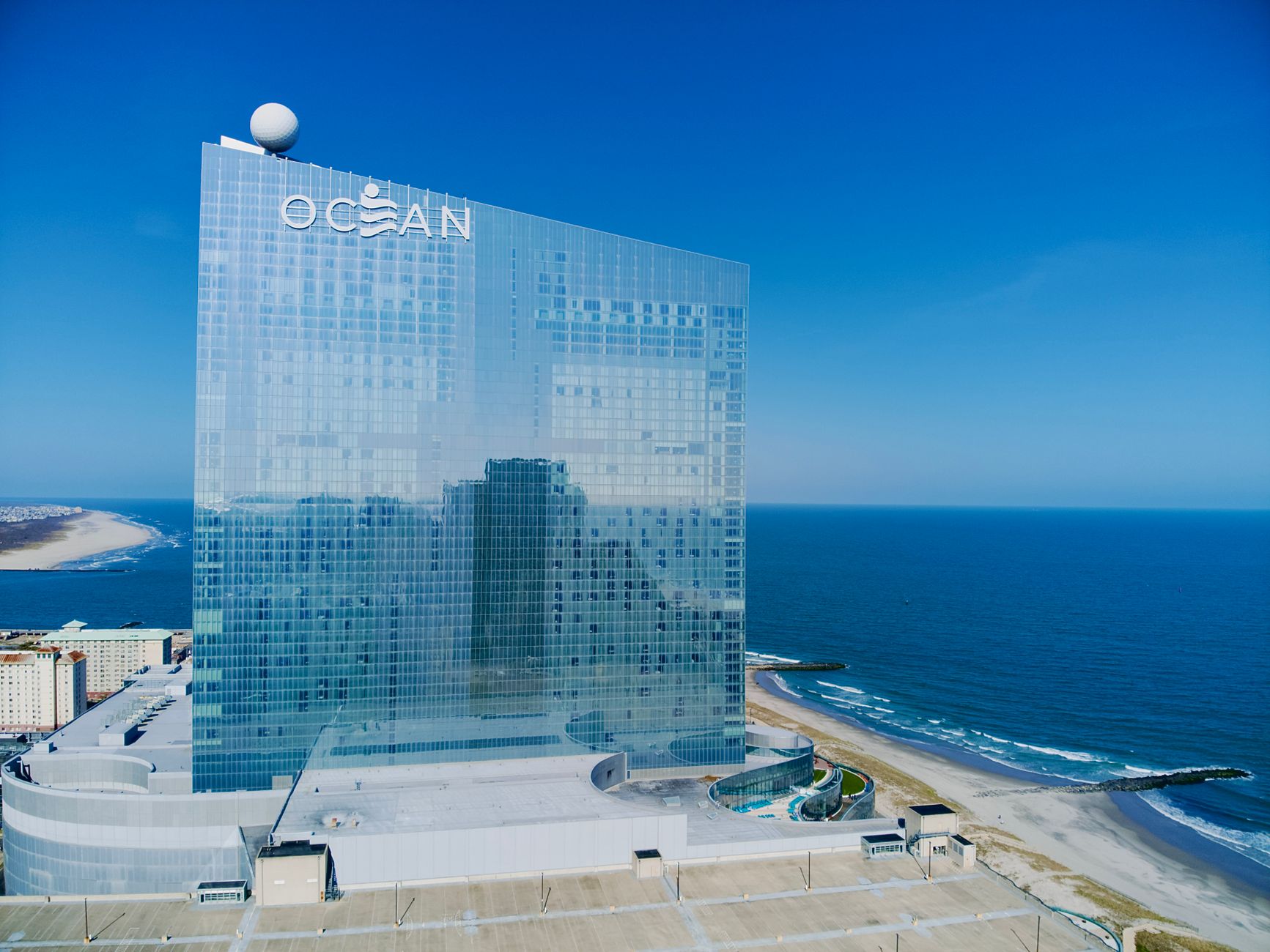 Aerial view of Ocean Casino Resort in Atlantic City with coastline and ocean reflections.