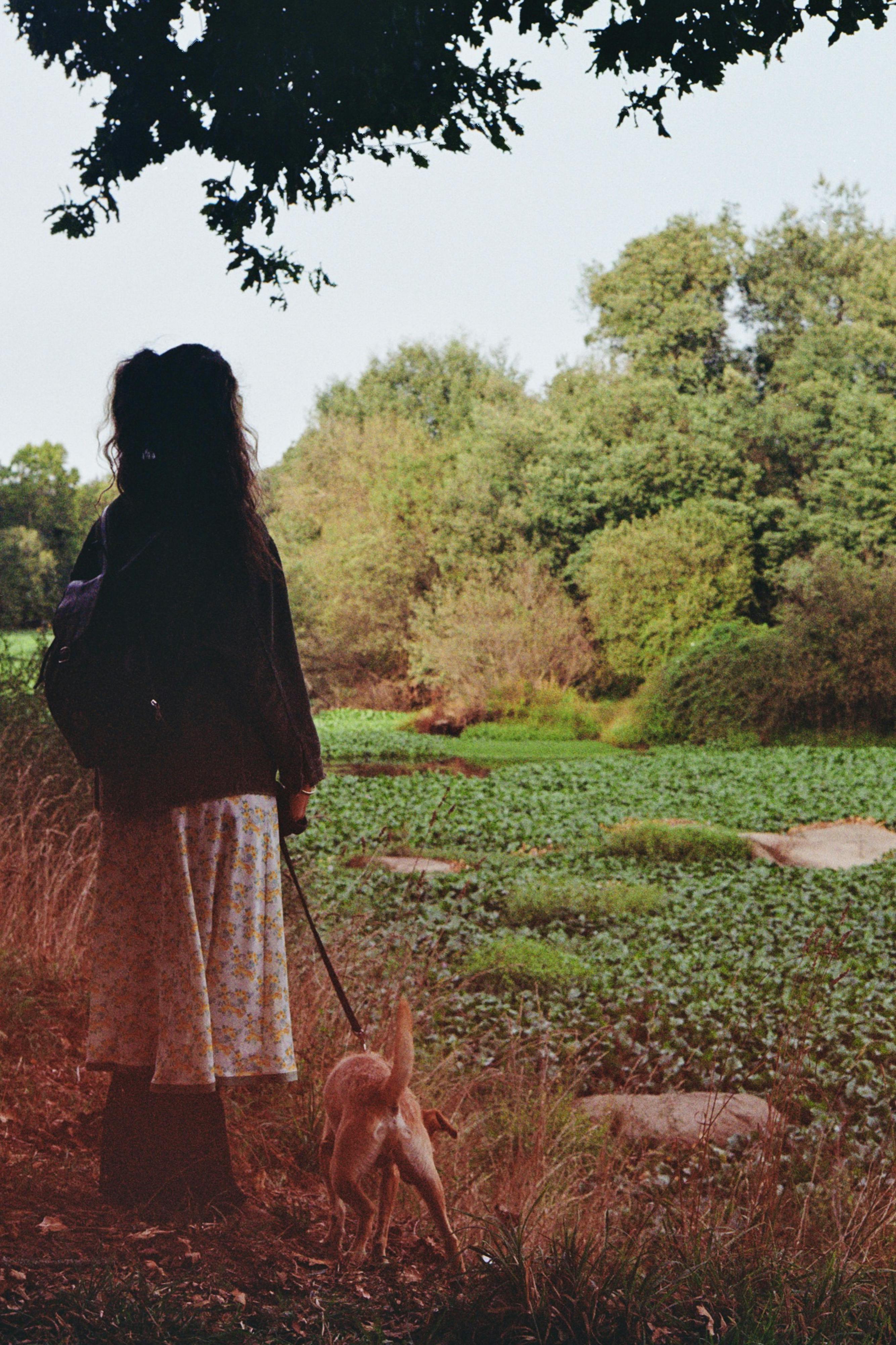 a woman walking her dog in the woods