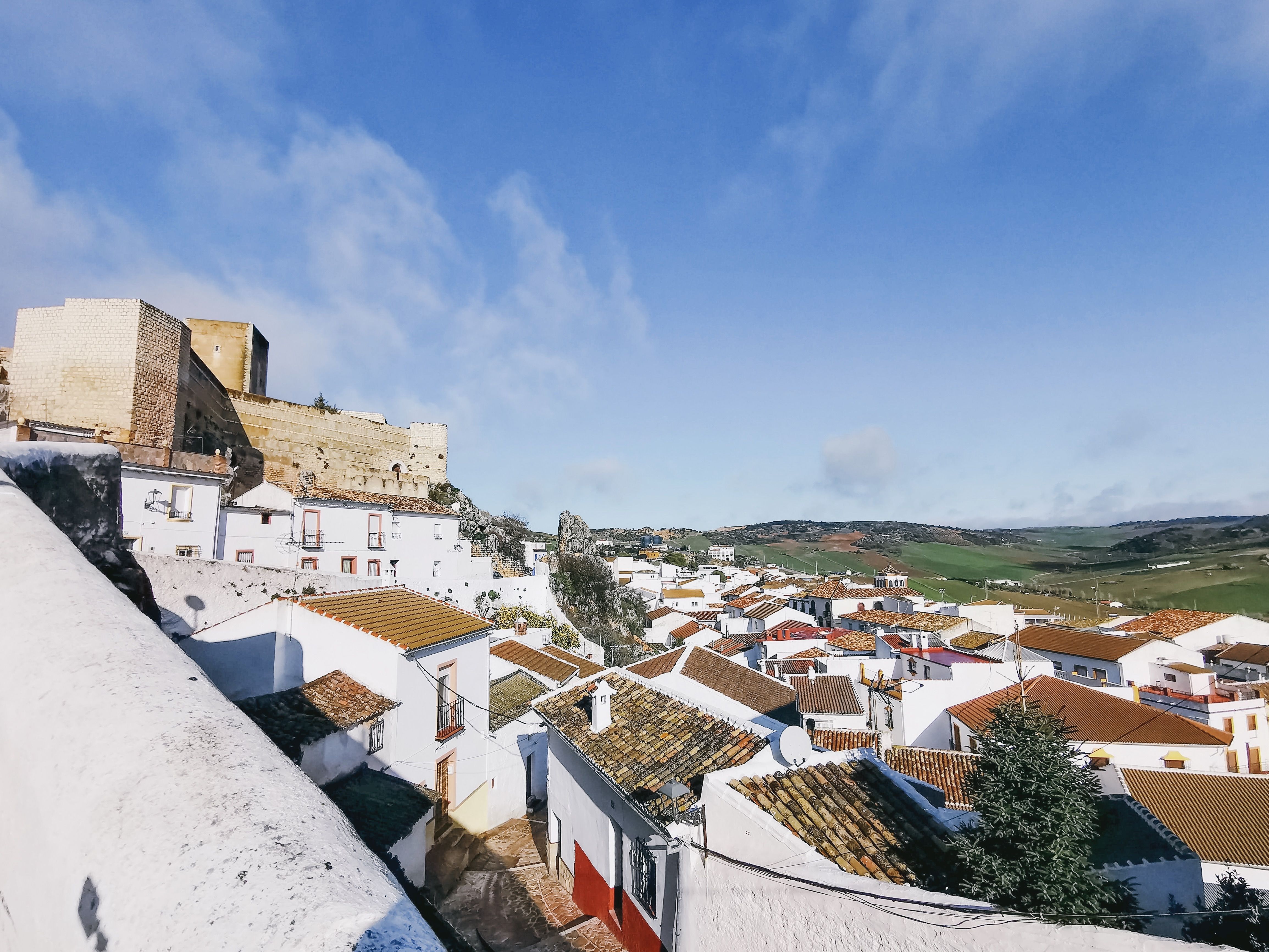 Scenic view of a Spanish town with whitewashed houses and a historic castle.