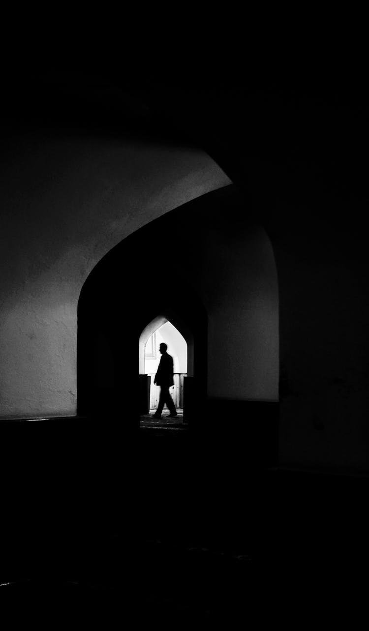 Silhouette Of A Person In The Arched Entrance To A Building 