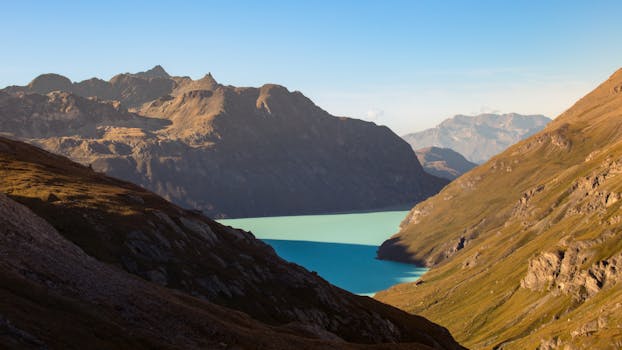 Beautiful alpine lake surrounded by rugged mountains under a clear blue sky.
