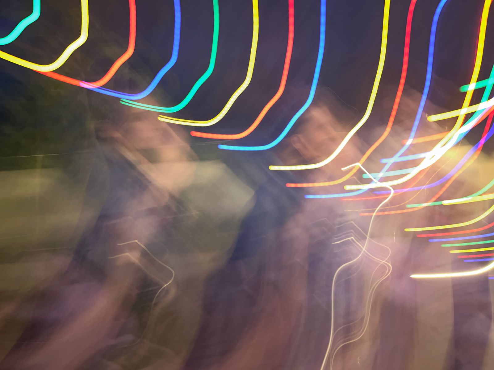 Traînées lumineuses abstraites sur des personnes floues en mouvement la nuit