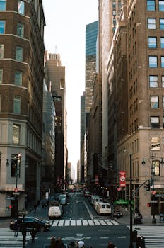 Iconic New York City street scene with tall skyscrapers and lively urban activity.