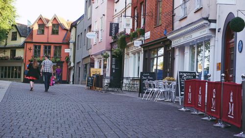 Free Scenic view of a cobblestone street in Norfolk, England, featuring colorful buildings and outdoor dining. Stock Photo