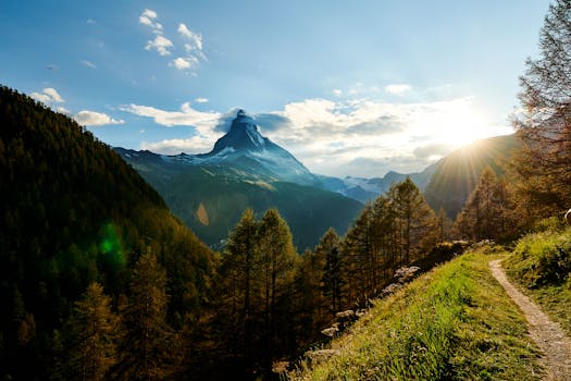 马特洪峰山顶的日出，在郁郁葱葱的绿植和晴朗蓝天的映衬下，景色格外壮美