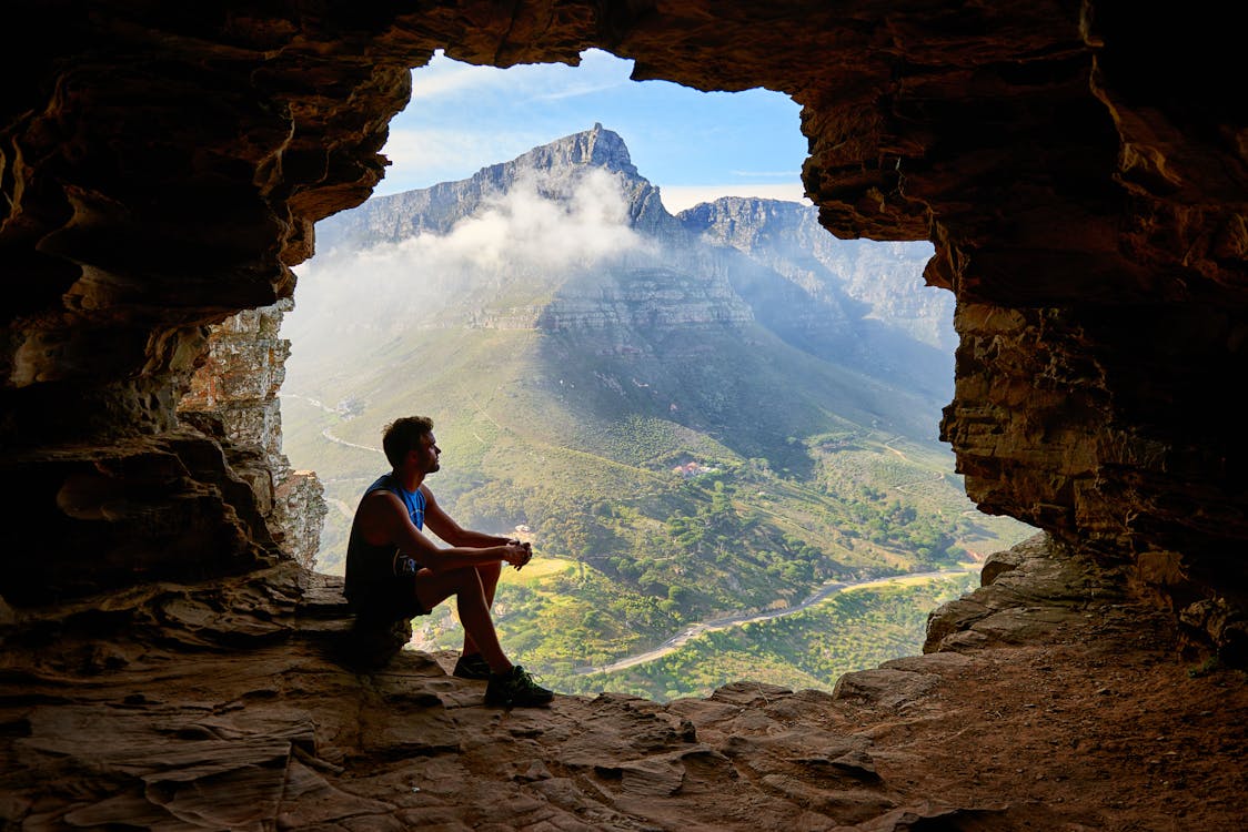 동굴에 앉아있는 남자의 사진