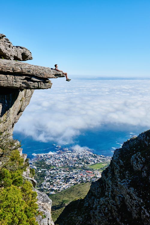 Free Person Sitting on Mountain Cliff Stock Photo