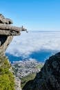 Person Sitting on Mountain Cliff