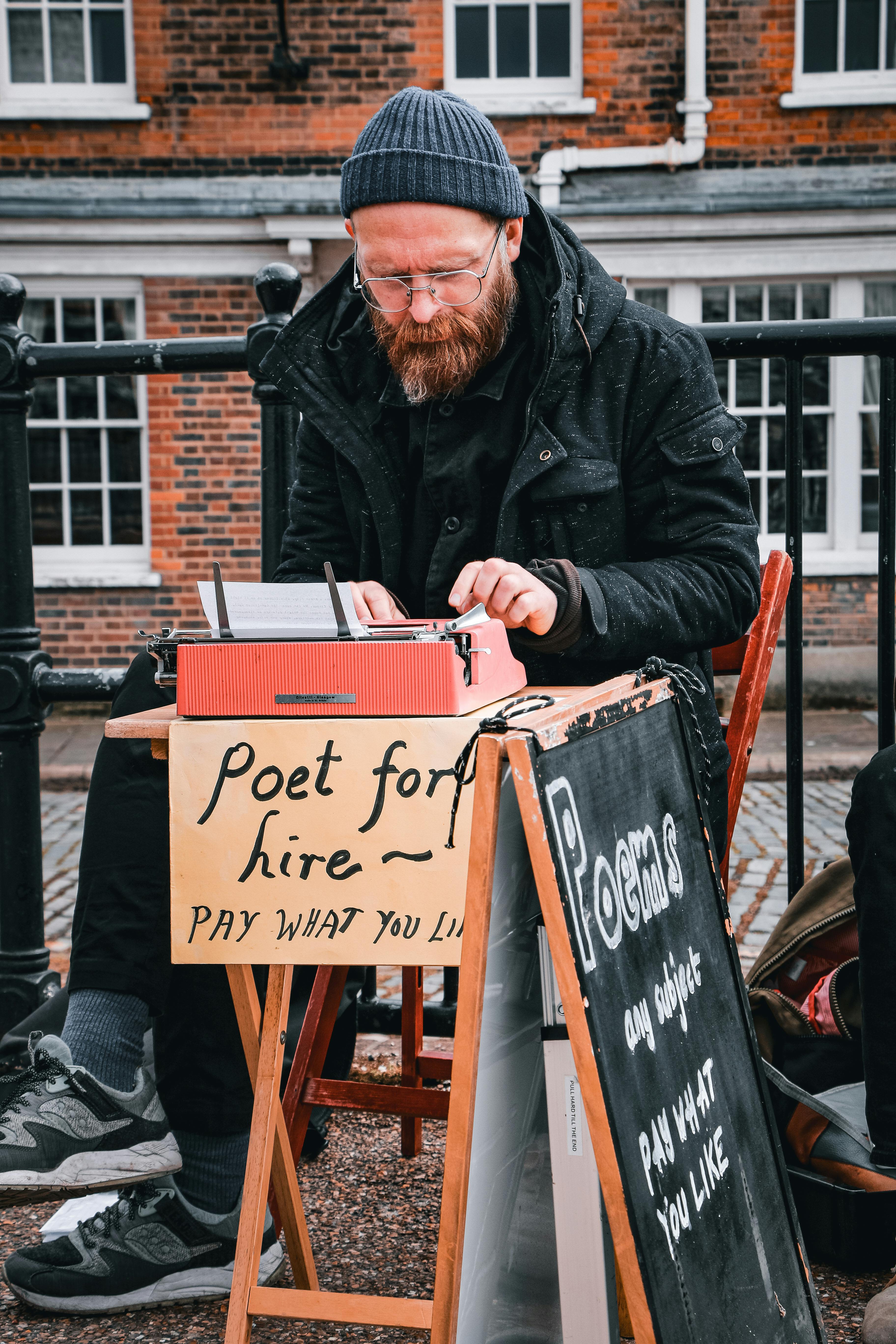 man sitting on the street and writing poems