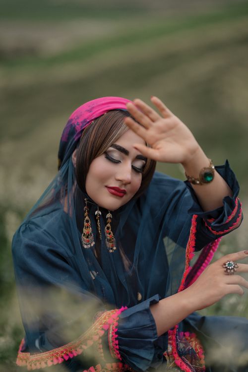 Free Outdoor fashion portrait of a woman in vibrant traditional dress and accessories. Stock Photo