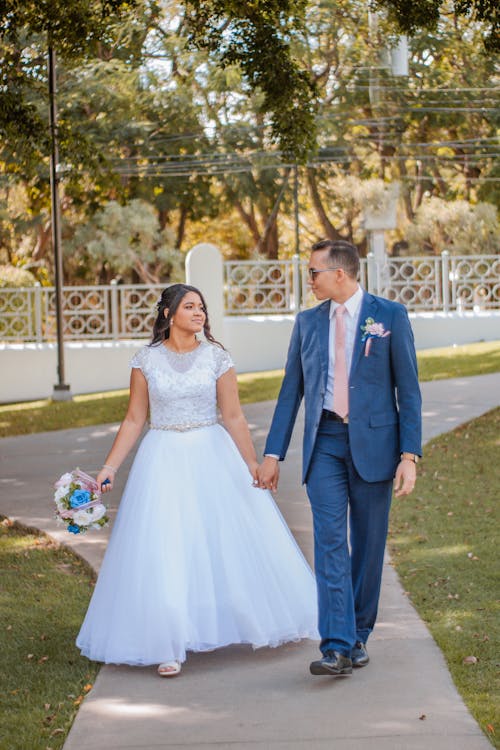 Newlyweds Walk with Holding Hands