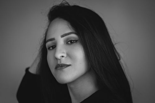 Free Elegant black and white studio portrait of a woman with long hair, hand in hair. Stock Photo