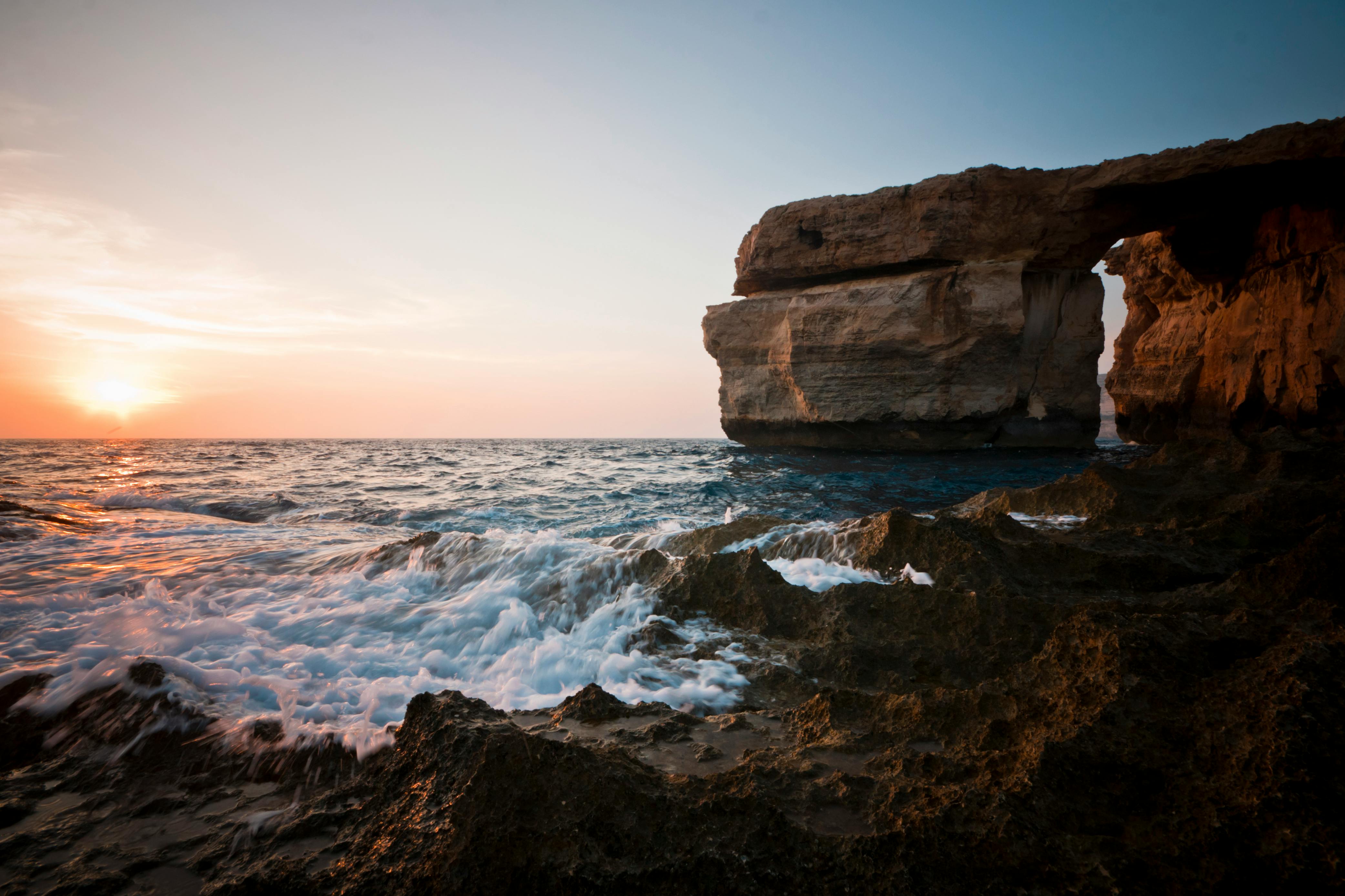 日落时分，海浪拍打着沿海的岩层，展现了大自然的美丽