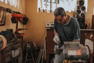 在车间里，熟练的工匠正专注于使用精密工具加工金属制品