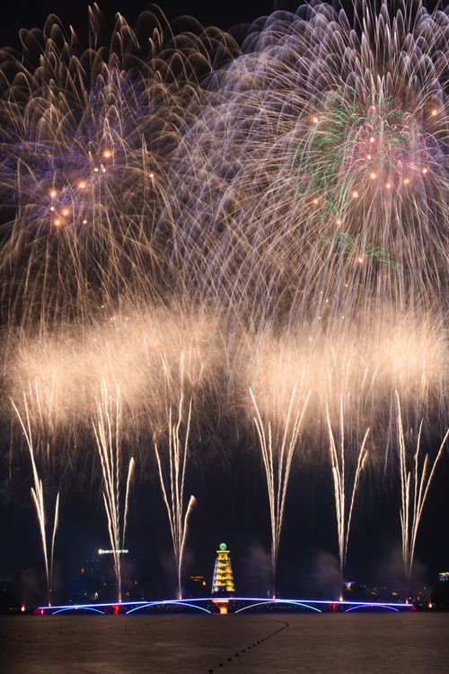Free Grand fireworks display brightens the night sky over a city bridge, perfect for festive celebrations. Stock Photo