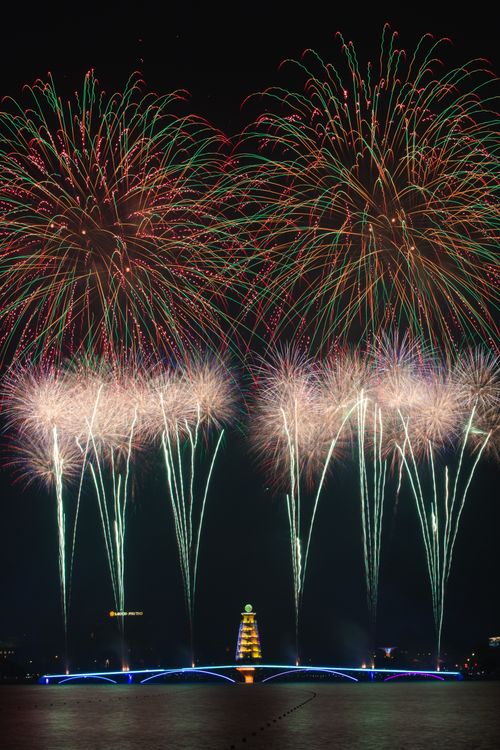 Free Stunning night view of colorful fireworks exploding over a cityscape during a festival celebration. Stock Photo