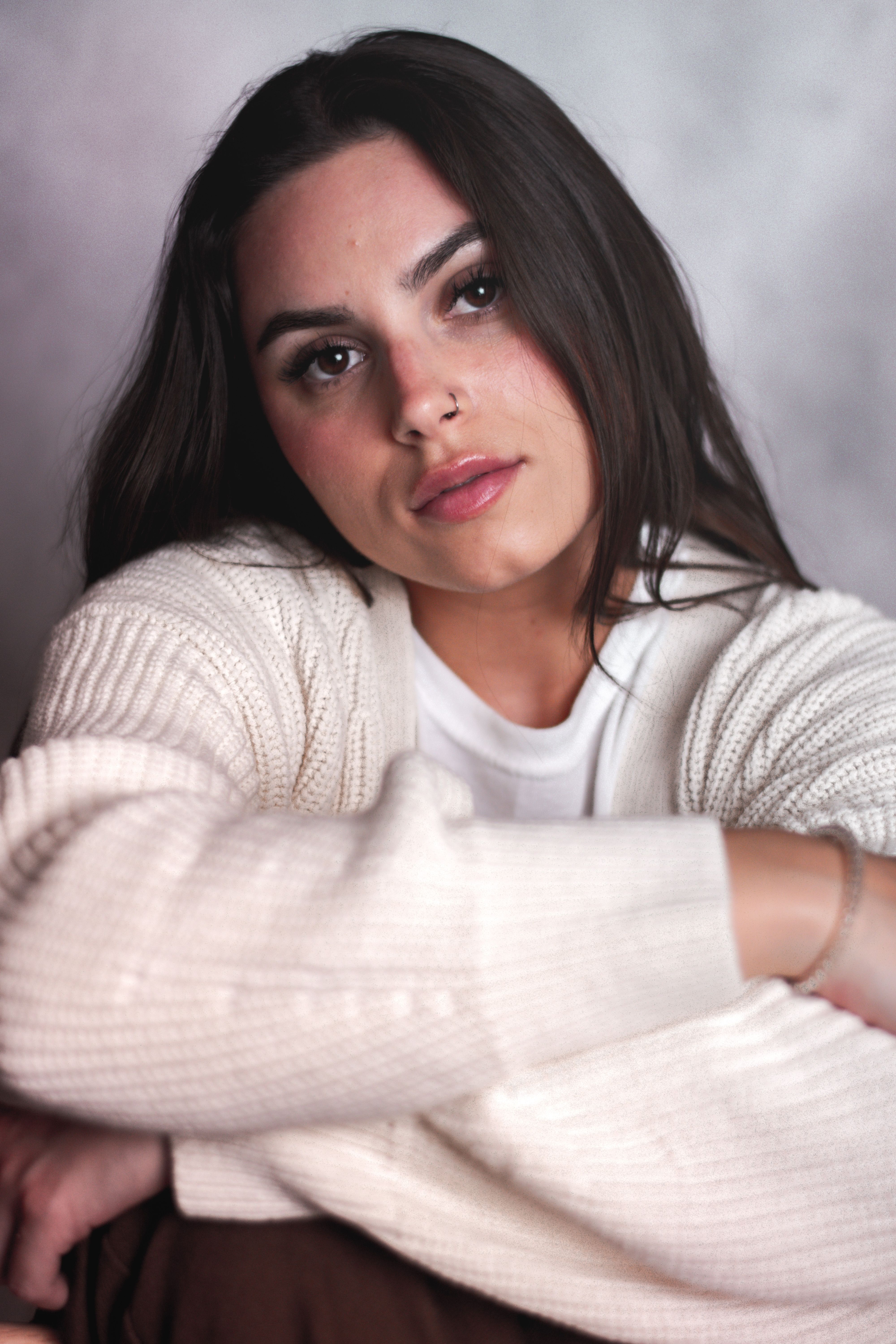 Stylish portrait of a brunette woman in cozy knitwear, exuding warmth and elegance.