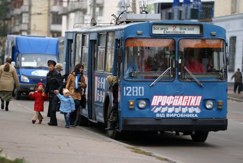 A blue bus with people on it