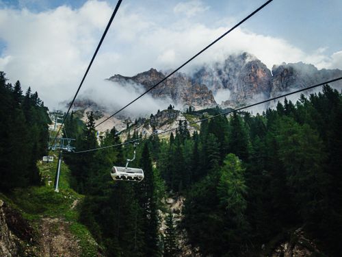 Free A scenic summer view of cable cars amidst the lush forests and rugged peaks of the Dolomites. Stock Photo