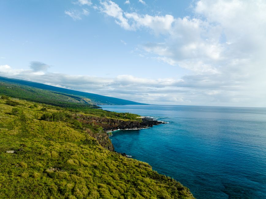 Best Maui to Big Island: Big Island Volcano Helicopter Tour & Ground Tour Review Review 2026 - A breathtaking aerial view of the lush coastline and crystal blue waters at Captain Cook, Hawaii.