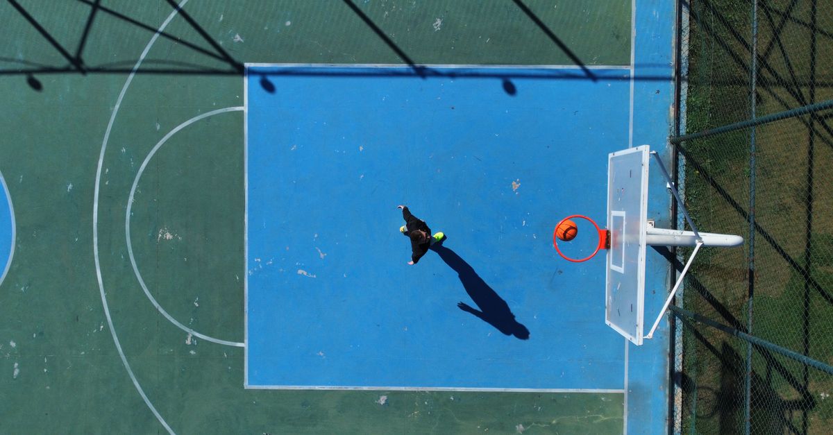A basketball court with AI-generated player tracking lines showing optimal defensive rotations