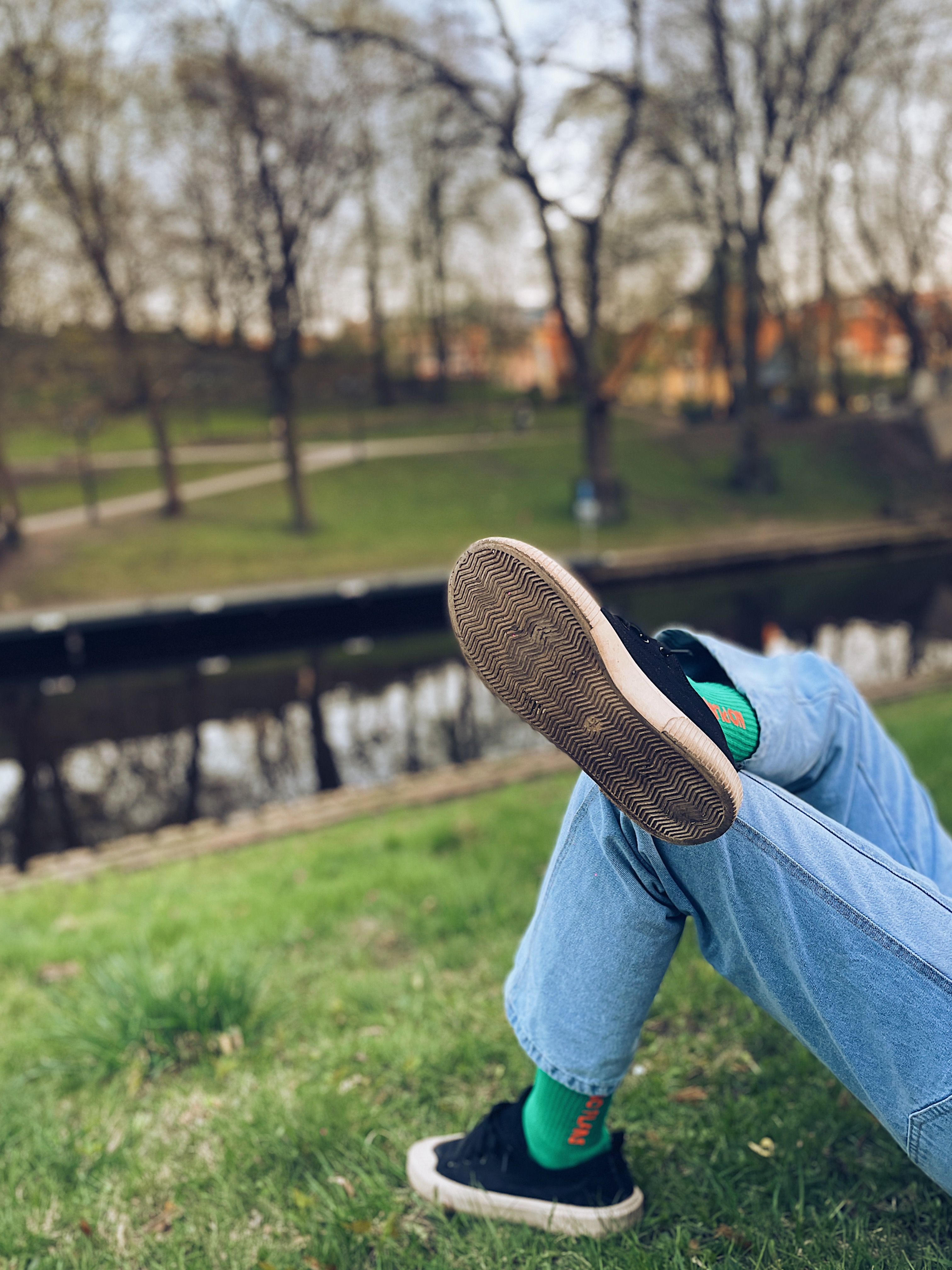 A person leisurely enjoying a day by the canal in Riga amidst nature.