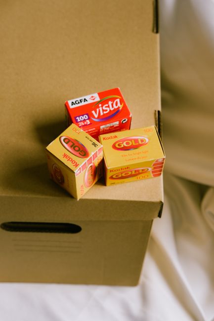 Close-up of vintage Kodak and Agfa Vista camera film boxes on a cardboard box.