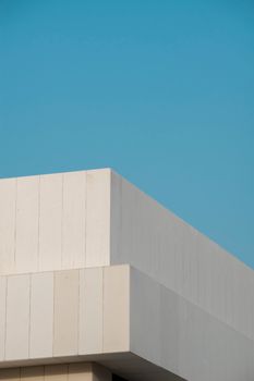 A minimalist building with clean lines and modern architecture against a clear blue sky.